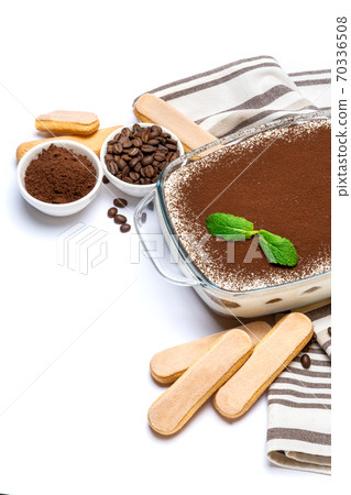 Traditional Italian Tiramisu dessert in glass baking dish and savoiardi cookies isolated on white Traditional Italian Tiramisu dessert in glass baking dish and savoiardi cookies isolated on white 70336508