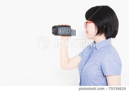 一個女人用攝像機拍攝視頻 一個女人用攝像機拍攝視頻 70336626
