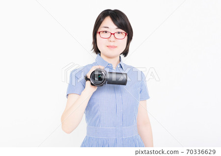 一個女人用攝像機拍攝視頻 一個女人用攝像機拍攝視頻 70336629