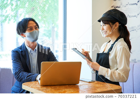 戴著透明口罩，在一家咖啡館點菜的女人 70337221