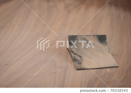 Piece of sandpaper on black walnut table Piece of sandpaper on black walnut table 70338543