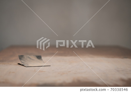 Piece of sandpaper on black walnut table 70338546