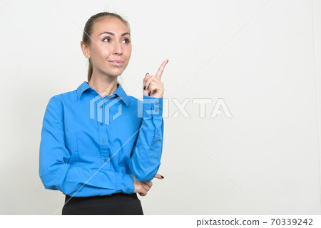 Portrait of young businesswoman thinking and pointing up Portrait of young businesswoman thinking and pointing up 70339242