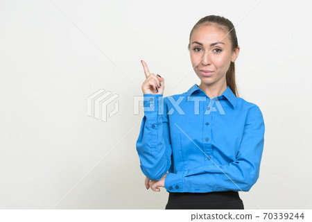 Portrait of young businesswoman with brown hair pointing up Portrait of young businesswoman with brown hair pointing up 70339244