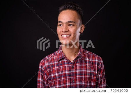 Face of happy young Indian hipster man thinking 70341000