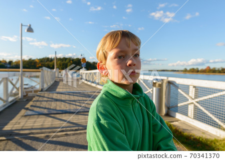 Young handsome boy at wooden pier near the river 70341370