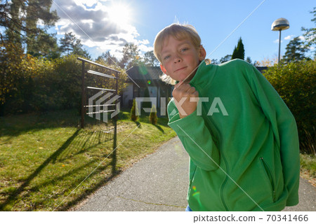 Young handsome boy with fist raised in the front yard Young handsome boy with fist raised in the front yard 70341466