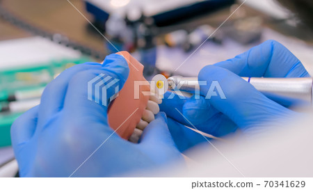 Dental technician working with dental prosthetics - close up view 70341629