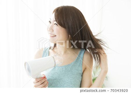 Woman doing a hair dryer 70343920