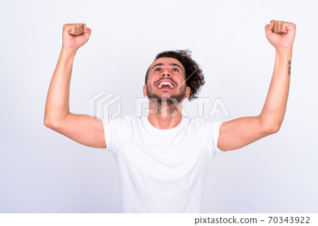 Portrait of happy bearded Turkish man with fists raised 70343922
