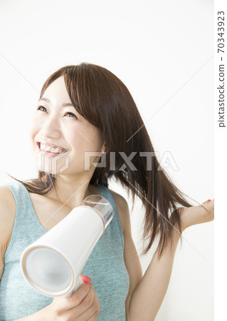 Woman doing a hair dryer 70343923