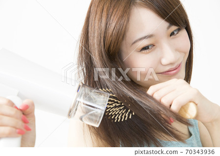 Woman doing a hair dryer 70343936