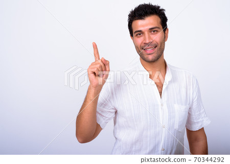 Portrait of happy handsome Turkish man pointing up Portrait of happy handsome Turkish man pointing up 70344292