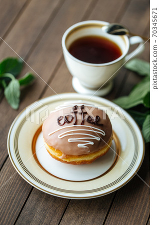 Coffee glazed donut with tea on the wooden table 70345671