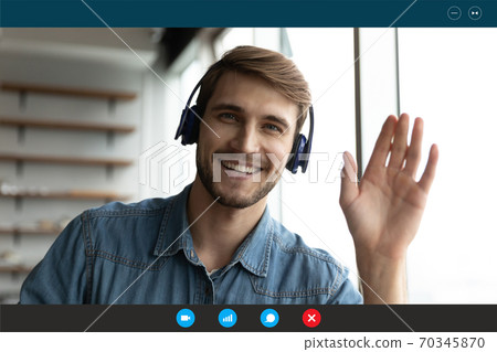 Portrait of smiling man in headphones talk on video call 70345870