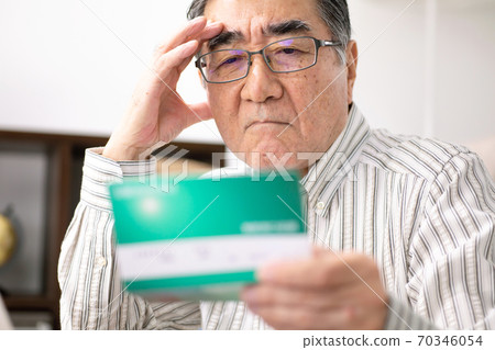 Male senior looking at passbook 70346054