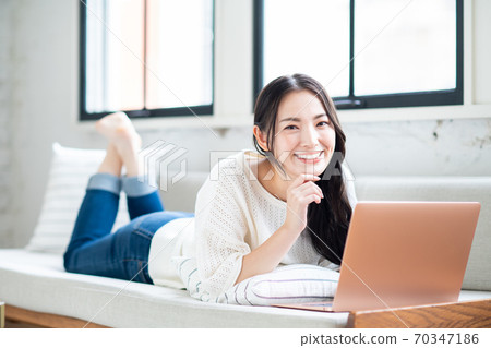 操作一台個人計算機的少婦在客廳 70347186
