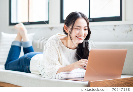 操作一台個人計算機的少婦在客廳 70347188