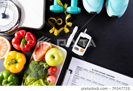 World diabetes day, Healthcare and medical concept. Healthy food including fresh fruits, vegetables, weight scale, sports shoes, dumbells, measure tape and diabetic measurement set on black