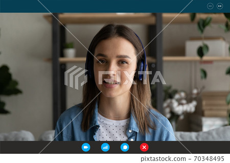 Young Caucasian woman in headphones speak on video call 70348495