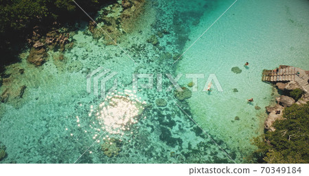 Top down sun reflecting, sparkling at emerald salt water lake. People swim, play in tropical lagoon Top down sun reflecting, sparkling at emerald salt water lake. People swim, play in tropical lagoon 70349184
