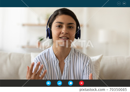 Indian woman in earphones talk on video call 70350085