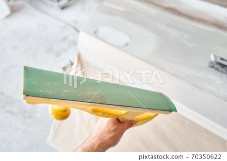 The mechanic works with a grinding tool. Sanding of car elements. Garage painting car service. Repairing car section after the accident. The mechanic works with a grinding tool. Sanding of car elements. Garage painting car service. Repairing car section after the accident. 70350622