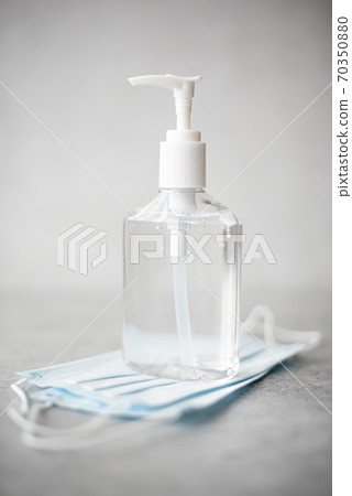 antiseptic hand gel in a transparent plastic bottle and mask 70350880
