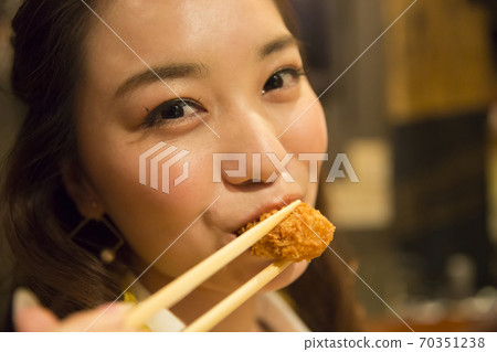 Woman eating fried oysters Woman eating fried oysters 70351238