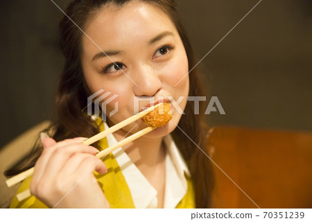 Woman eating fried oysters Woman eating fried oysters 70351239
