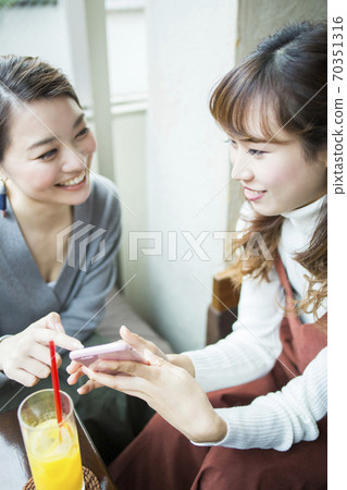 一個女人在一家咖啡館聊天 一個女人在一家咖啡館聊天 70351316
