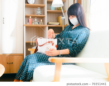 Pregnant woman putting her hand in her bag 4: 3 70351441
