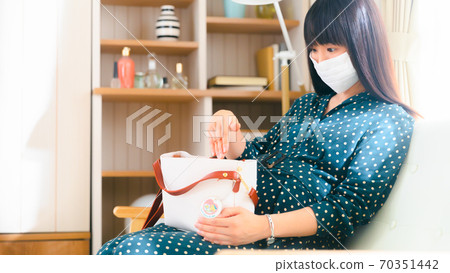 Pregnant woman putting her hand in her bag 16: 9 Pregnant woman putting her hand in her bag 16: 9 70351442