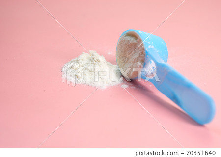 Close up of baby milk powder and spoon on pink background. Close up of baby milk powder and spoon on pink background. 70351640