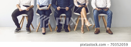 Group of unrecognizable candidates sitting on chairs waiting for an interview. Group of unrecognizable candidates sitting on chairs waiting for an interview. 70352059
