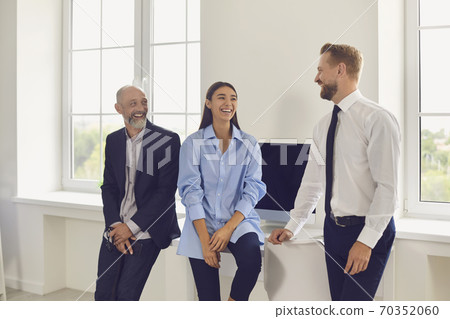 Young smiling business people looking at each other in office during startup or project discussion Young smiling business people looking at each other in office during startup or project discussion 70352060