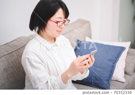 A woman using a smartphone A woman using a smartphone 70352336