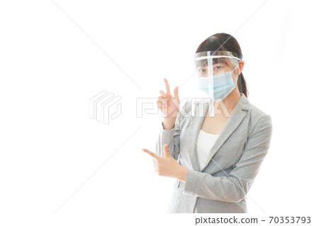 A young business woman who wears a face shield and points to a point 70353793
