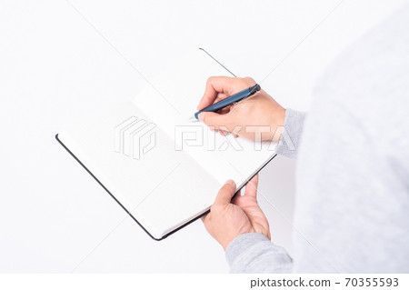 A man writing notes in a notebook 70355593