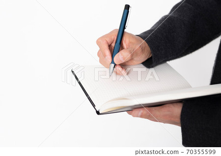 A man writing notes in a notebook 70355599