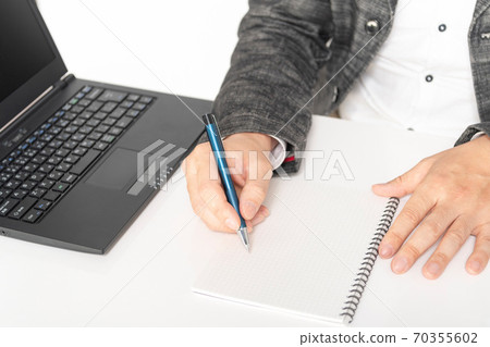 A man writing notes in a notebook 70355602