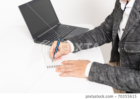 A man writing notes in a notebook 70355615
