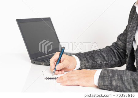 A man writing notes in a notebook 70355616