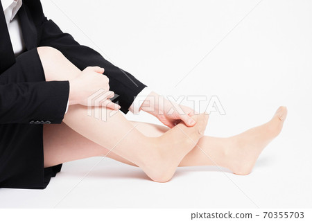 A woman with a foot massage A woman with a foot massage 70355703