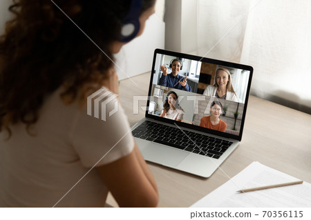 Rear view of woman talk on video call with girlfriends 70356115