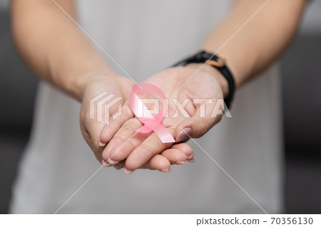 woman holding pink ribbon to support breast cancer awareness month for fight with cancer 70356130