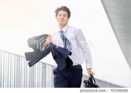 A man in a suit running with a bag A man in a suit running with a bag 70356606