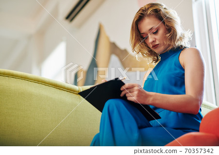 Woman correcting document Woman correcting document 70357342