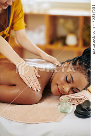 Enjoying back massage with oils Enjoying back massage with oils 70357581