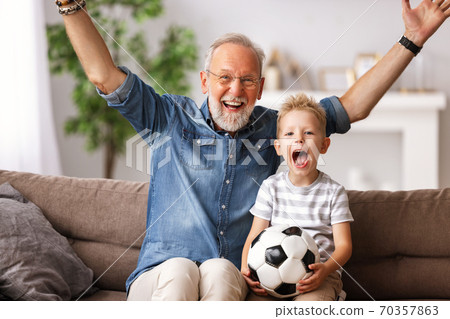 Excited grandfather and grandson watching football match on TV. Excited grandfather and grandson watching football match on TV. 70357863